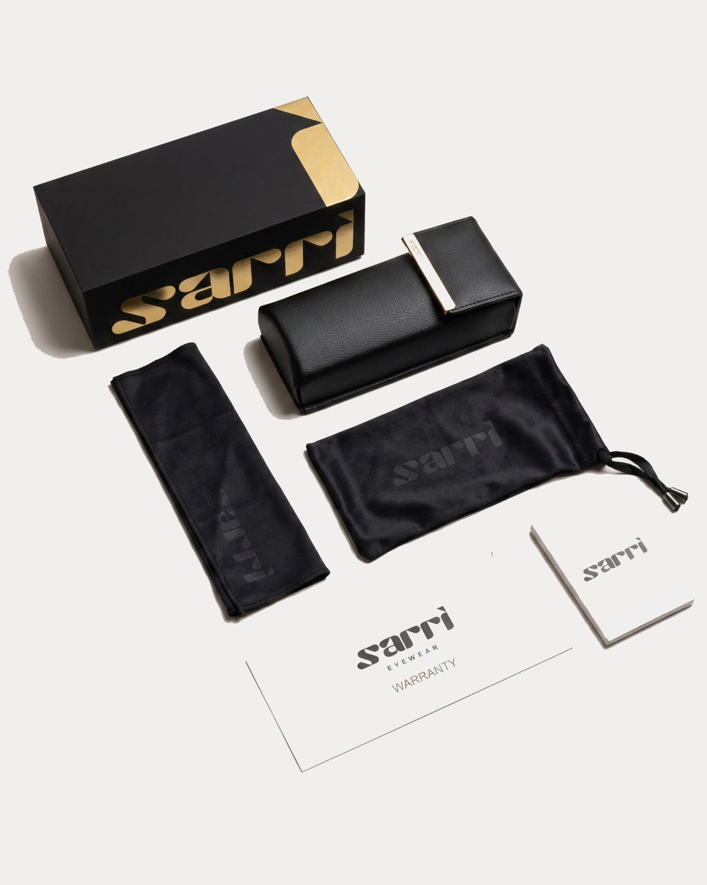 Sarri eyewear packaging set with black case, pouch, and warranty card on a white background