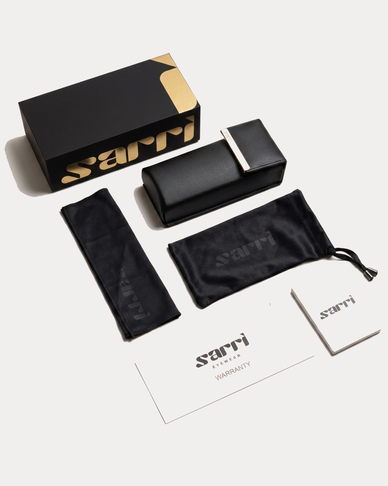 Sarri eyewear packaging set with black case, pouch, and warranty card on a white background
